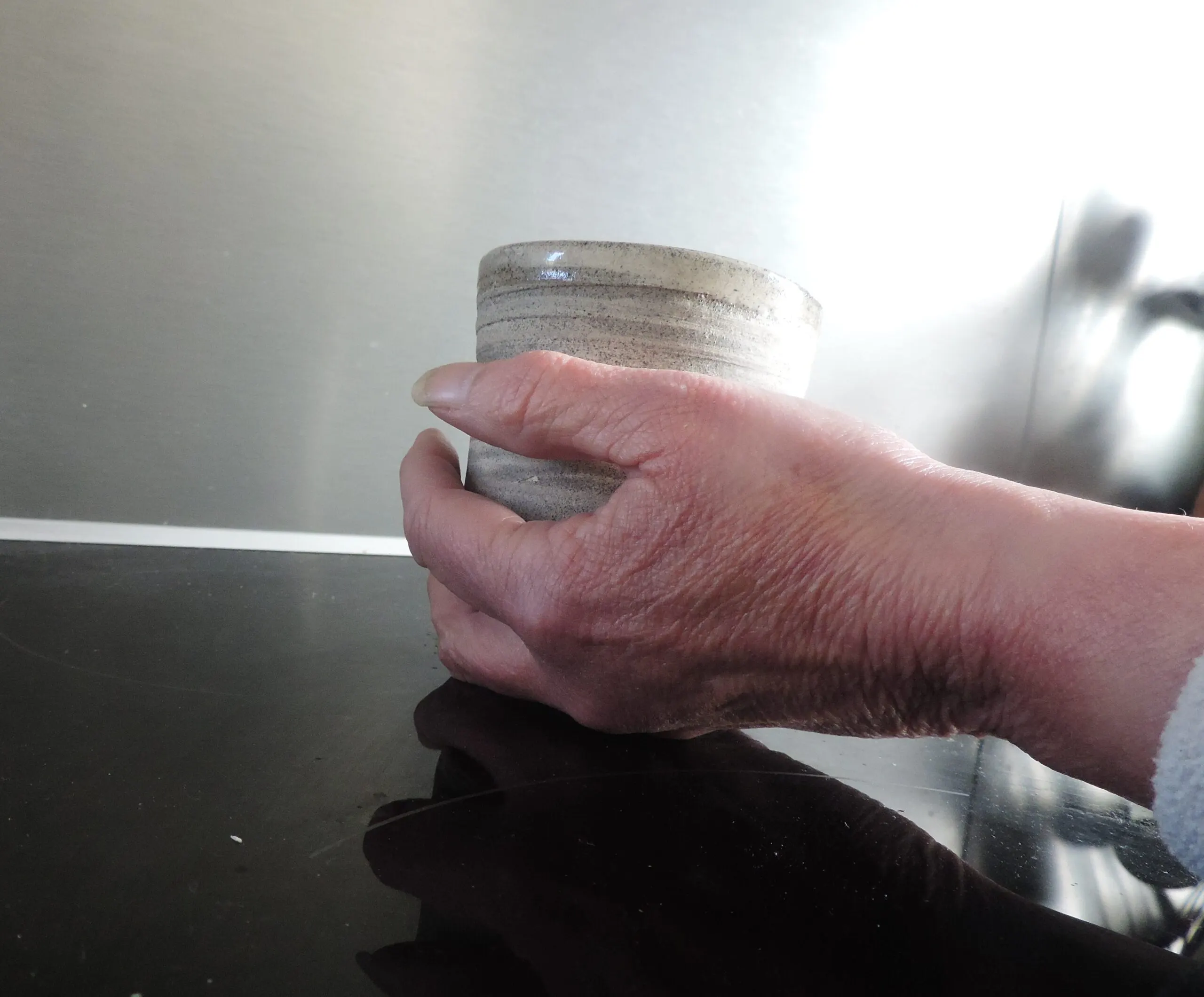 Une main tenant un bol de céramique artisanale