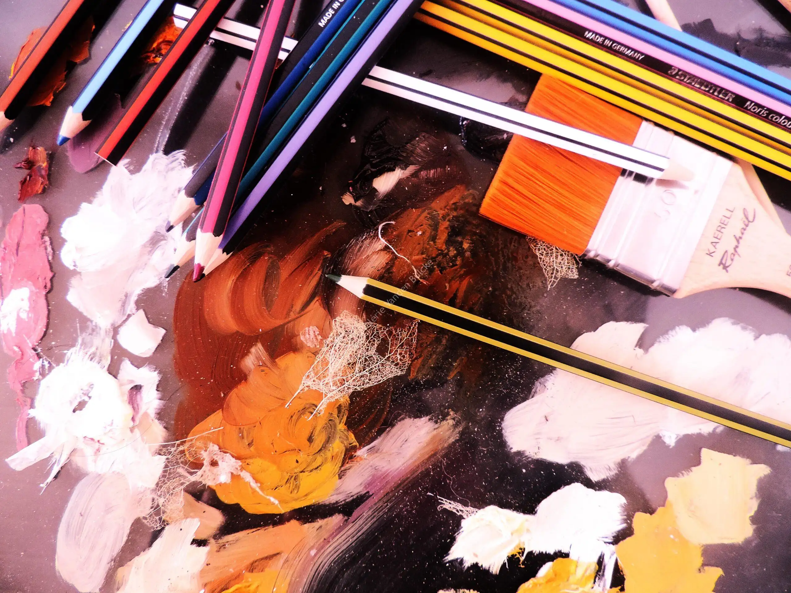 La table de l'atelier&nbsp;: crayons, pinceaux et couleurs en cours de travail